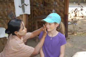 Charlie goes native. Burmese women and children often wear this beige paste on their faces for beauty, sunscreen and mosquito repellent!